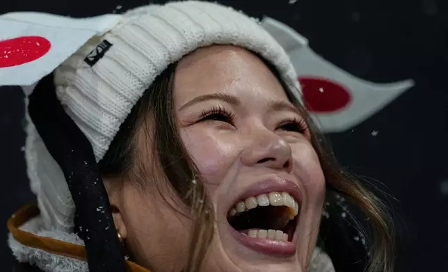 A fan for Japan cheers before the women's snowboarding halfpipe finals at the 2026 Winter Olympics, in Livigno, Italy, Thursday, Feb. 12, 2026. (AP Photo/Julia Demaree Nikhinson)