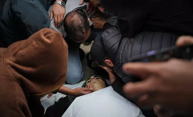 Palestinians mourn over the body of Hamas militant Firas al-Najjar, who was killed in an Israeli military strike, during his funeral at Nasser Hospital in Khan Younis, Gaza Sunday, Feb. 15, 2026. (AP Photo/Abdel Kareem Hana)