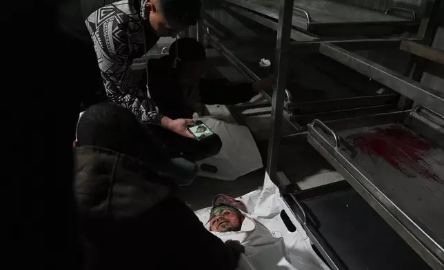 Palestinians mourn over the body of Hamas militant Baraa Al-Shaqra, who was killed in an Israeli military strike, during his funeral at Nasser Hospital in Khan Younis, Gaza, Sunday, Feb. 15, 2026. (AP Photo/Abdel Kareem Hana)