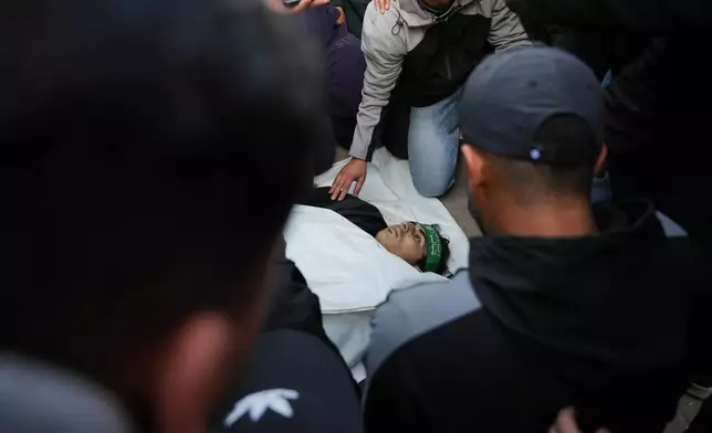 Palestinians mourn over the body of Hamas militant Firas al-Najjar, who was killed in an Israeli military strike, during his funeral at Nasser Hospital in Khan Younis, Gaza Sunday, Feb. 15, 2026. (AP Photo/Abdel Kareem Hana)
