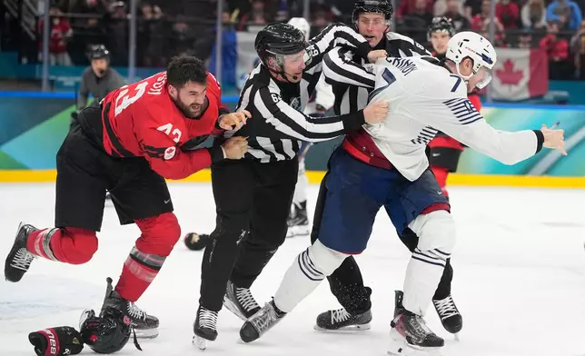 France's Pierre Crinon (7) and Canada's Tom Wilson (43) fight in the third period during a preliminary round game of men's ice hockey between Canada and France at the 2026 Winter Olympics, in Milan, Italy, Sunday, Feb. 15, 2026. (AP Photo/Hassan Ammar)