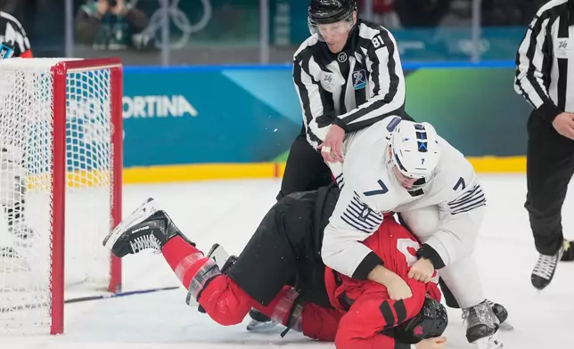 France's Pierre Crinon (7) and Canada's Tom Wilson (43) fight in the third period during a preliminary round game of men's ice hockey between Canada and France at the 2026 Winter Olympics, in Milan, Italy, Sunday, Feb. 15, 2026. (AP Photo/Hassan Ammar)