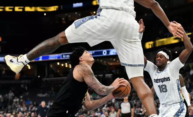 Golden State Warriors forward Gui Santos, lower left, looks to shoot between Memphis Grizzlies forward Olivier-Maxence Prosper (18) and Memphis Grizzlies guard Javon Small, top, in the first half of an NBA basketball game Wednesday, Feb. 25, 2026, in Memphis, Tenn. (AP Photo/Brandon Dill)
