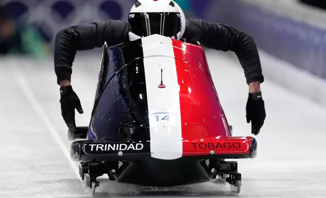 Trinidad And Tobago's Axel Brown, front, starts for a two man bobsled training session at the 2026 Winter Olympics, in Cortina d'Ampezzo, Italy, Thursday, Feb. 12, 2026. (AP Photo/Aijaz Rahi)