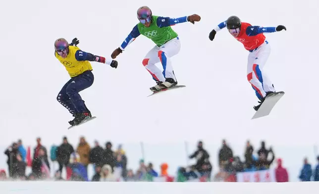 United States' Nathan Pare (13), France's Jonas Chollet (4) and France's Loan Bozzolo (5) compete during the men's snowboard cross finals at the 2026 Winter Olympics, in Livigno, Italy, Thursday, Feb. 12, 2026. (AP Photo/Lindsey Wasson)