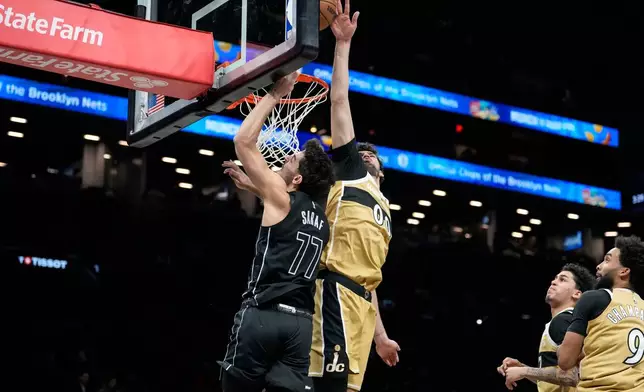Brooklyn Nets guard Ben Saraf (77) is blocked by Washington Wizards forward Tristan Vukcevic (00) during the first half of an NBA basketball game, Saturday, Feb. 7, 2026, in New York. (AP Photo/Yuki Iwamura)