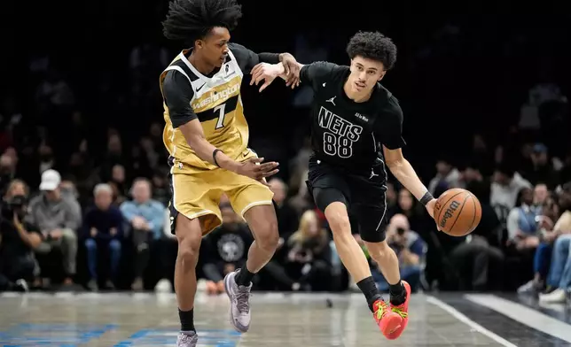 Brooklyn Nets guard Nolan Traore (88) drives past Washington Wizards guard Bub Carrington (7) during the first half of an NBA basketball game, Saturday, Feb. 7, 2026, in New York. (AP Photo/Yuki Iwamura)