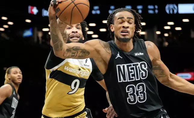 Brooklyn Nets center Nic Claxton (33) fights for control of the ball with Washington Wizards forward Justin Champagnie (9) during the first half of an NBA basketball game, Saturday, Feb. 7, 2026, in New York. (AP Photo/Yuki Iwamura)