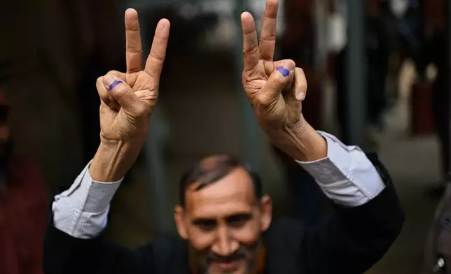 A person shows victory signs after casting his vote outside a polling center during the national parliamentary elections in Dhaka, Bangladesh, Thursday, Feb. 12, 2026. (AP Photo/Mahmud Hossain Opu)
