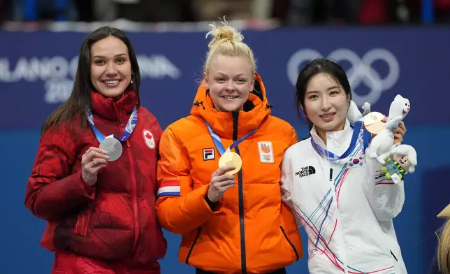 From left to right, silver medalist Courtney Sarault of Canada, gold medalist Xandra Velzeboer of the Netherlands and bronze medalist Kim Gilli of South Korea receive their medals after the short track speed skating women's 1000m at the 2026 Winter Olympics, in Milan, Italy, Monday, Feb. 16, 2026. (AP Photo/Francisco Seco)