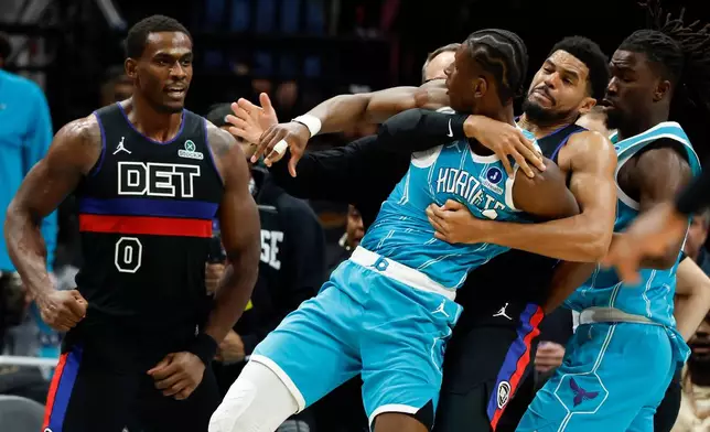 Charlotte Hornets forward Moussa Diabate, front right, is held back as he fights with Detroit Pistons center Jalen Duren (0) fight during the second half of an NBA basketball game in Charlotte, N.C., Monday, Feb. 9, 2026. (AP Photo/Nell Redmond)