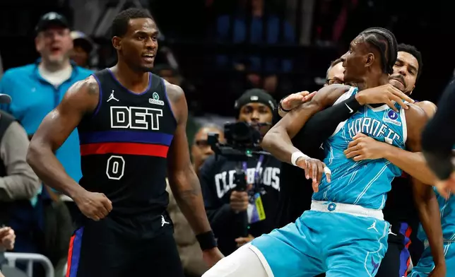 Charlotte Hornets forward Moussa Diabate, front right, is held back as he fights Detroit Pistons center Jalen Duren (0) on the court in the second half of an NBA basketball game in Charlotte, N.C., Monday, Feb. 9, 2026. (AP Photo/Nell Redmond)