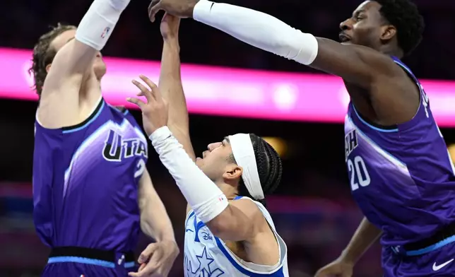 Orlando Magic guard Anthony Black (0) is fouled by Utah Jazz forward Lauri Markkanen, left, while going up to shoot, as center Jaren Jackson Jr. (20) helps defend during the first half of an NBA basketball game, Saturday, Feb. 7, 2026, in Orlando, Fla. (AP Photo/Phelan M. Ebenhack)
