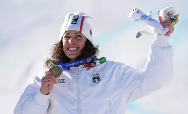 Italy's Federica Brignone shows her gold medal in an alpine ski, women's giant slalom race, at the 2026 Winter Olympics, in Cortina d'Ampezzo, Italy, Sunday, Feb. 15, 2026. (AP Photo/Jacquelyn Martin)