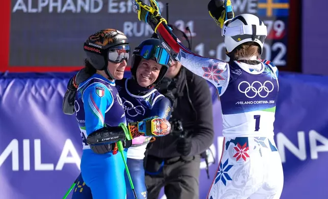 Bronze medalist Norway's Thea Louise Stjernesund, right, and silver medalist Sweden's Sara Hector, center, celebrate with gold medal's winner Italy's Federica Brignone, left, following an alpine ski, women's giant slalom race, at the 2026 Winter Olympics, in Cortina d'Ampezzo, Italy, Sunday, Feb. 15, 2026. (AP Photo/Robert F. Bukaty)