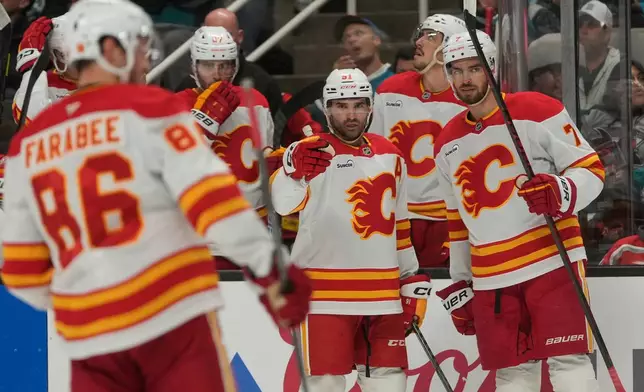 Calgary Flames center Nazem Kadri, middle, is congratulated by teammates after scoring against the San Jose Sharks during the second period of an NHL hockey game in San Jose, Calif., Thursday, Feb. 26, 2026. (AP Photo/Jeff Chiu)