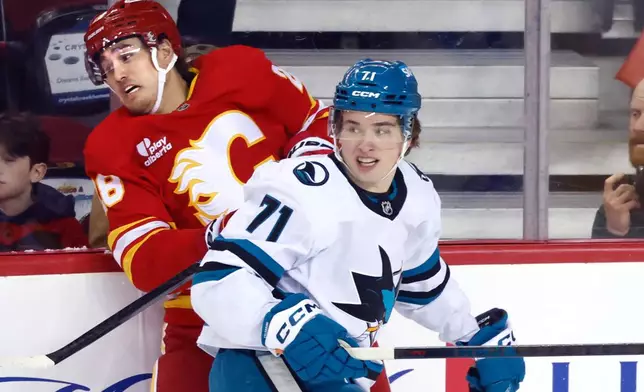San Jose Sharks' Macklin Celebrini (71) collides with Calgary Flames' Zach Whitecloud, left, during first-period NHL hockey game action in Calgary, Alberta, Saturday, Jan. 31, 2026. (Larry MacDougal/The Canadian Press via AP)