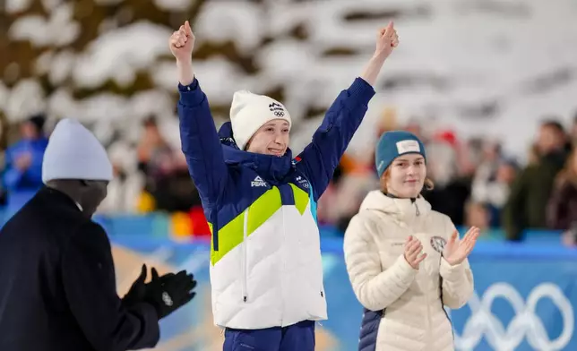 Gold medalist Anna Odine Stroem, of Norway, right, applauds silver medalist Nika Prevc, of Slovenia, on the podium of the ski jumping women's normal hill individual, at the 2026 Winter Olympics, in Predazzo, Italy, Saturday, Feb. 7, 2026. (AP Photo/Evgeniy Maloletka)