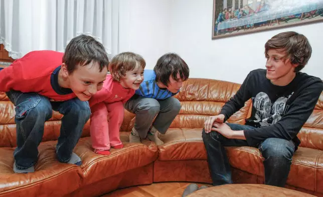 From left, Domen, Nika and Cene Prevc gesture as their older brother Peter looks on, in the living room of the Prevc family house, in Dolenja Vas village, in Slovenia, March, 22, 2010. (Gorazd Kavcic via AP)