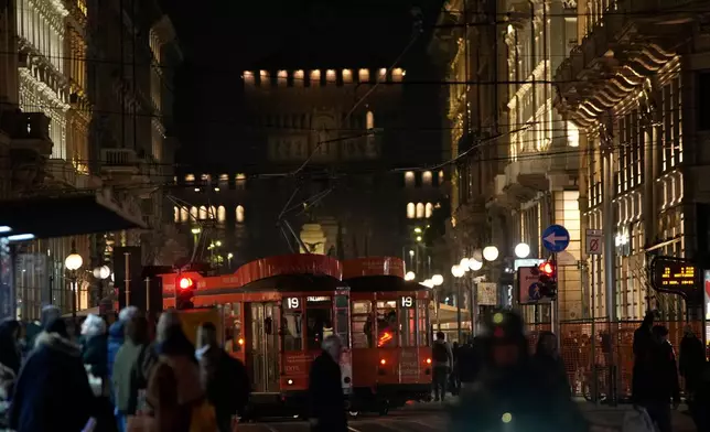 A traditional vintage tram travels on rails through a downtown street, in Milan, Italy, Friday, Nov. 7, 2025. (AP Photo/Luca Bruno)