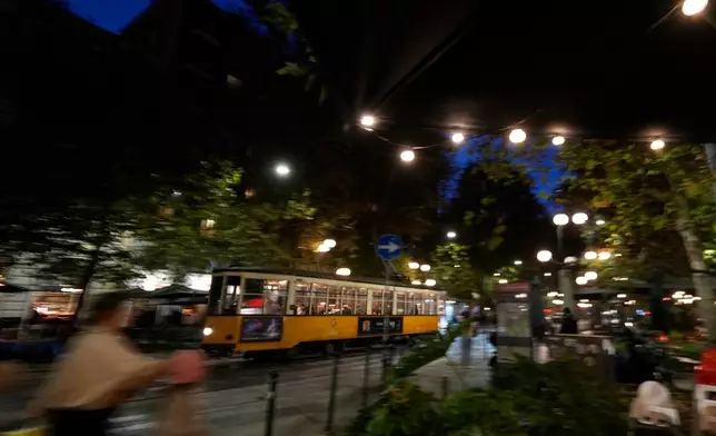 A traditional vintage tram travels on rails through a downtown street, in Milan, Italy, Friday, Nov. 7, 2025. (AP Photo/Luca Bruno)