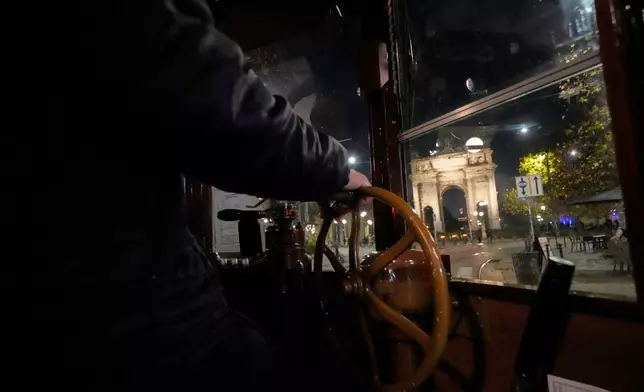 An operator controls command levels of a traditional vintage tram near to the Peace Arch during a Tram tour, in Milan, Italy, Saturday, Dec. 6, 2025. (AP Photo/Luca Bruno)