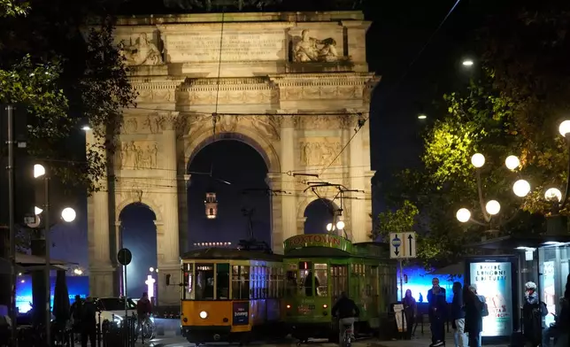 Traditional vintage trams travel on rails through a downtown street near to the Peace Arch, in Milan, Italy, Friday, Nov. 7, 2025. (AP Photo/Luca Bruno)