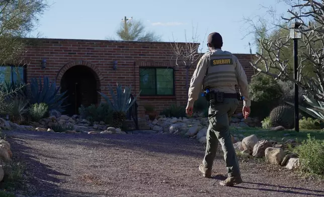 A member of the Pima County sheriffs office remains outside of Nancy Guthrie's home, Monday, Feb. 9, 2026 in Tucson, Ariz. (AP Photo/Ty ONeil)