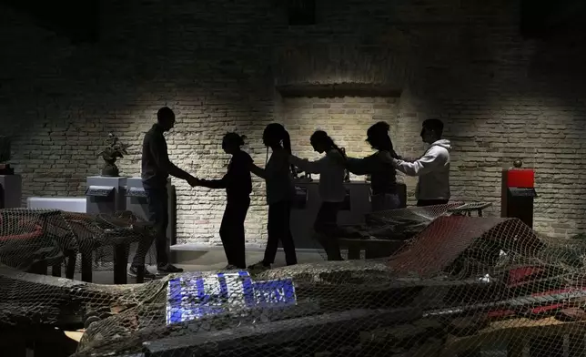 Blindfolded students of an art high school enter the pavilion of contemporary art for a project on tactile experience at the Omero Tactile Museum in Ancona, Italy, Friday, Jan. 16, 2026. (AP Photo/Alessandra Tarantino)