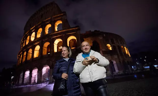 Michela Marcato, left, who is blind, and her partially sighted partner Massimiliano Naccarato pose for a photo during a visit to the Colosseum in Rome, Wednesday, Dec. 17, 2025. (AP Photo/Alessandra Tarantino)