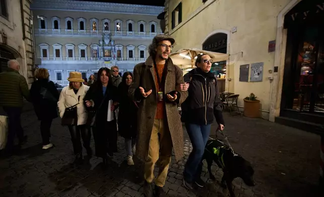 Giorgio Guardi, center, a guide from the Radici Association, walks with participants during one of their inclusive art tours in central Rome, Nov. 29, 2025. (AP Photo/Alessandra Tarantino)