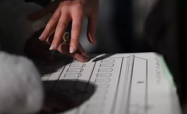 Francesca Inglese, who is blind, uses a tactile panel to experience the architecture of Palazzo Farnese during an inclusive art tour in downtown Rome, Nov. 29, 2025. (AP Photo/Alessandra Tarantino)