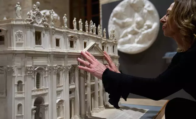 Stefania Terre, who is blind, touches a reproduction of St. Peter's Basilica at the Omero Tactile Museum in Ancona, Italy, Thursday, Jan. 15, 2026. (AP Photo/Alessandra Tarantino)