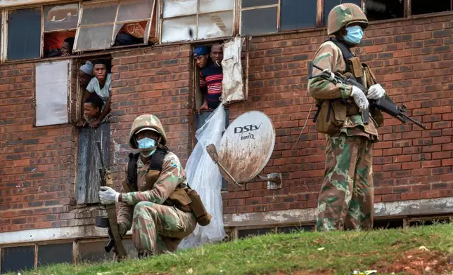 FILE - South African National Defense Forces patrol the Men's Hostel in the densely populated Alexandra township east of Johannesburg, Saturday, March 28, 2020. (AP Photo/Jerome Delay, File)