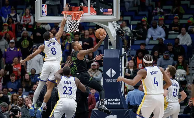New Orleans Pelicans guard Dejounte Murray (5) shoots against Golden State Warriors guard De'anthony Melton (8) and forward Draymond Green (23) during the first half of an NBA basketball game in New Orleans, Tuesday, Feb. 24, 2026. (AP Photo/Matthew Hinton)