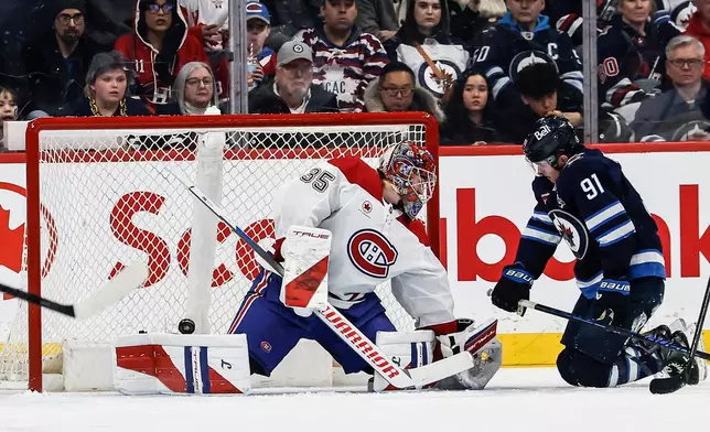 Winnipeg Jets' Kyle Connor scores on Montreal Canadiens goaltender Samuel Montembeault (35) as Cole Perfetti (91) looks on during the first period of an NHL hockey game in Winnipeg, Manitoba, Wednesday, Feb. 4, 2026. (John Woods/The Canadian Press via AP)