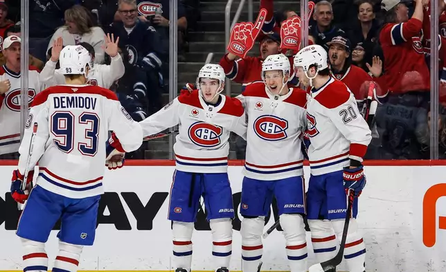 Montreal Canadiens' Oliver Kapanen, second right, celebrates his goal against the Winnipeg Jets with Ivan Demidov, left to right, Lane Hutson and Juraj Slafkovsky during the first period of an NHL hockey game in Winnipeg, Manitoba, Wednesday, Feb. 4, 2026. (John Woods/The Canadian Press via AP)