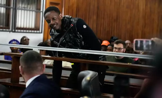 Bellarmine Chatunga Mugabe, son of former Zimbabwe President Robert Mugabe, chats with his attorney as he appears at the Alexandra Magistrates Court in Johannesburg, South Africa, Monday, Feb. 23, 2026, on charges stemming from last week's Hyde Park shooting incident. (AP Photo/Themba Hadebe)