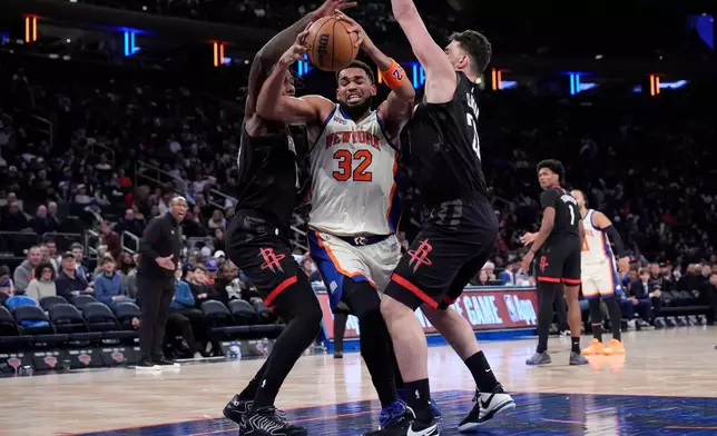 New York Knicks center Karl-Anthony Towns (32) drives past Houston Rockets forward Tari Eason (17) and Houston Rockets center Alperen Sengun (28) during the second half of an NBA basketball game, Saturday, Feb. 21, 2026, in New York. (AP Photo/Yuki Iwamura)
