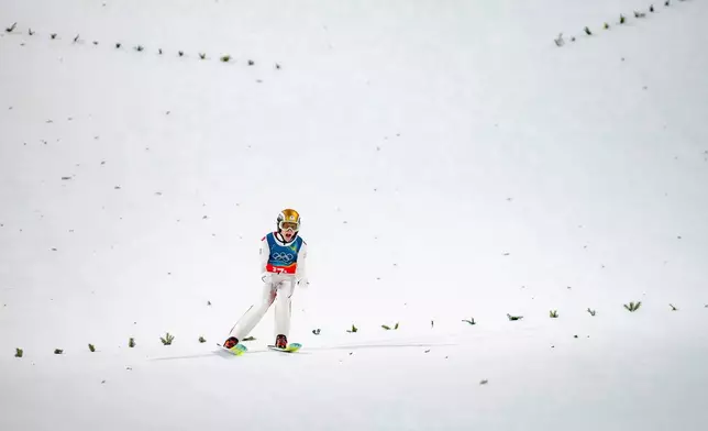 Jan Hoerl, of Austria, reacts after his final round jump of the ski jumping men's super team competition at the 2026 Winter Olympics, in Predazzo, Italy, Monday, Feb. 16, 2026. (AP Photo/Evgeniy Maloletka)