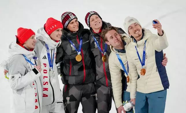 Gold medalists Stephan Embacher and Jan Hoerl, of Austria, pose on the podium, with silver medalists Pawel Wasek and Kacper Tomasiak, of Poland, and bronze medalists Kristoffer Eriksen Sundal and Johann Andre Forfang, of Norway, after the ski jumping men's super team competition at the 2026 Winter Olympics, in Predazzo, Italy, Monday, Feb. 16, 2026. (AP Photo/Matthias Schrader)
