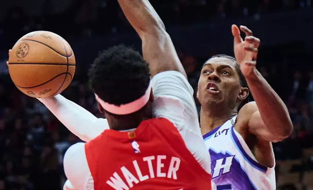 Utah Jazz's Cody Williams, right, is blocked at the net by Toronto Raptors' Ja'Kobe Walter during the first half of an NBA basketball game in Toronto, Sunday, Feb. 1, 2026. (Sammy Kogan/The Canadian Press via AP)