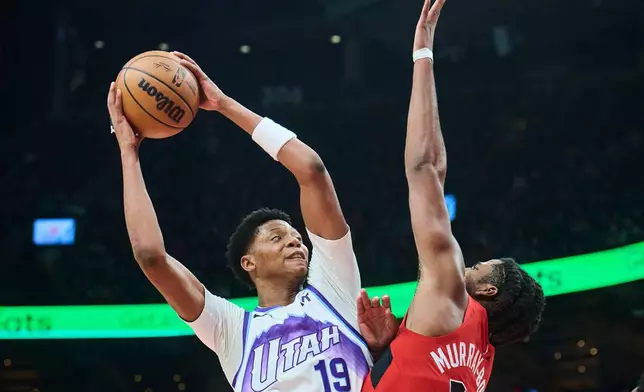 Utah Jazz's Ace Bailey (19) is blocked on a drive to the net by Toronto Raptors' Collin Murray-Boyles during the first half of an NBA basketball game in Toronto, Sunday, Feb. 1, 2026. (Sammy Kogan/The Canadian Press via AP)