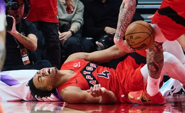 Toronto Raptors' Scottie Barnes (4) grimaces after being fouled during the first half of an NBA basketball game against the Utah Jazz in Toronto, Sunday, Feb. 1, 2026. (Sammy Kogan/The Canadian Press via AP)