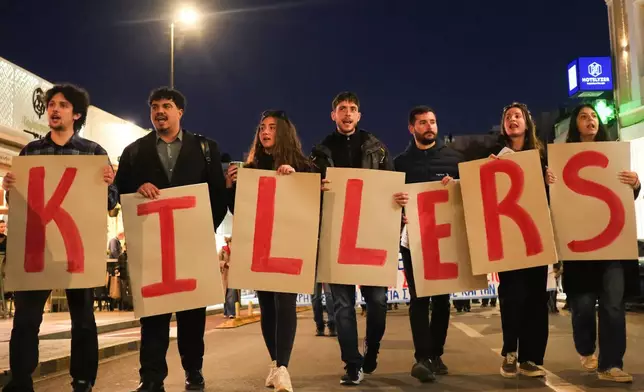 Protesters take part in an anti-war rally in Chania, Greece, opposing the docking of the aircraft carrier USS Gerald R. Ford at the nearby Souda Bay naval base on the southern island of Crete, Tuesday, Feb. 24, 2026. (AP Photo/Giannis Angelakis)