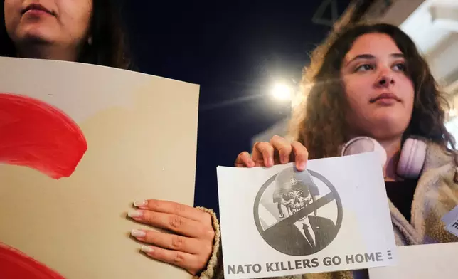 Protesters take part in an anti-war rally in Chania, Greece, opposing the docking of the aircraft carrier USS Gerald R. Ford at the nearby Souda Bay naval base on the southern island of Crete, Tuesday, Feb. 24, 2026. (AP Photo/Giannis Angelakis)