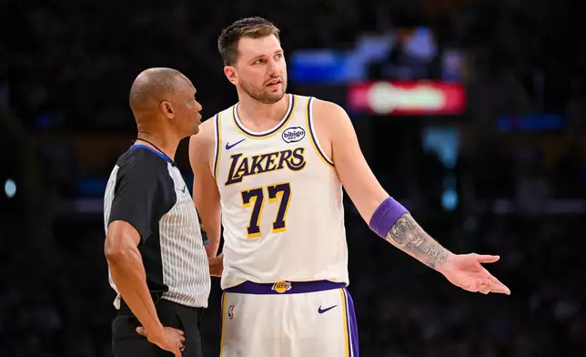 Los Angeles Lakers guard Luka Doncic speaks to referee Michael Smith during the first half of an NBA basketball game against the Boston Celtics, Sunday, Feb. 22, 2026, in Los Angeles. (AP Photo/Katie Chin)