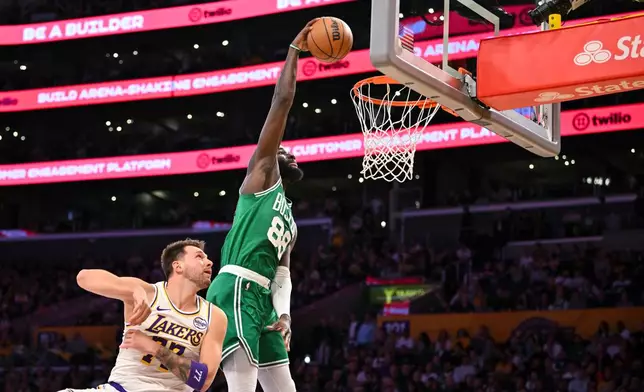 Boston Celtics center Neemias Queta, right, dunks the ball against Los Angeles Lakers guard Luka Doncic, left, during the first half of an NBA basketball game Sunday, Feb. 22, 2026, in Los Angeles. (AP Photo/Katie Chin)