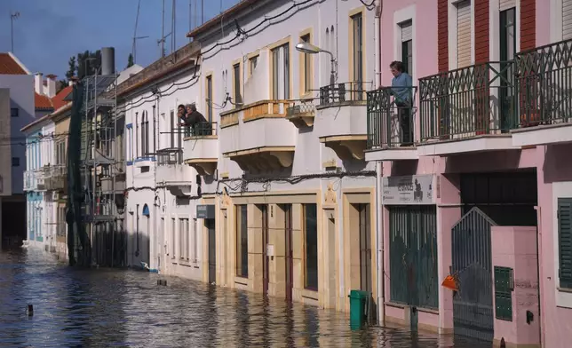 Residents looks at a flooded street after the Sado River overflowed following heavy rains in Alcácer do Sal, southern Portugal, Friday, Feb. 6, 2026. (AP Photo/Ana Brigida)