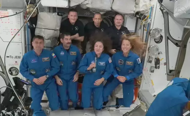 In this image from video provided by NASA, foreground from left, Russian Andrei Fedyaev, Americans Jack Hathaway and Jessica Meir and France’s Sophie Adenot, gather with, background from left, Russian Sergey Kud-Sverchkov, American Christopher Williams and Russian Sergei Mikayev, after a new crew entered the International Space Station on Saturday, Feb. 14, 2026. (NASA via AP)